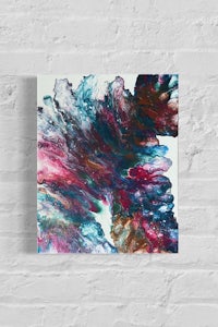 an abstract painting hanging on a brick wall