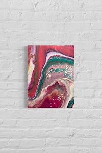 a red and green abstract painting on a brick wall